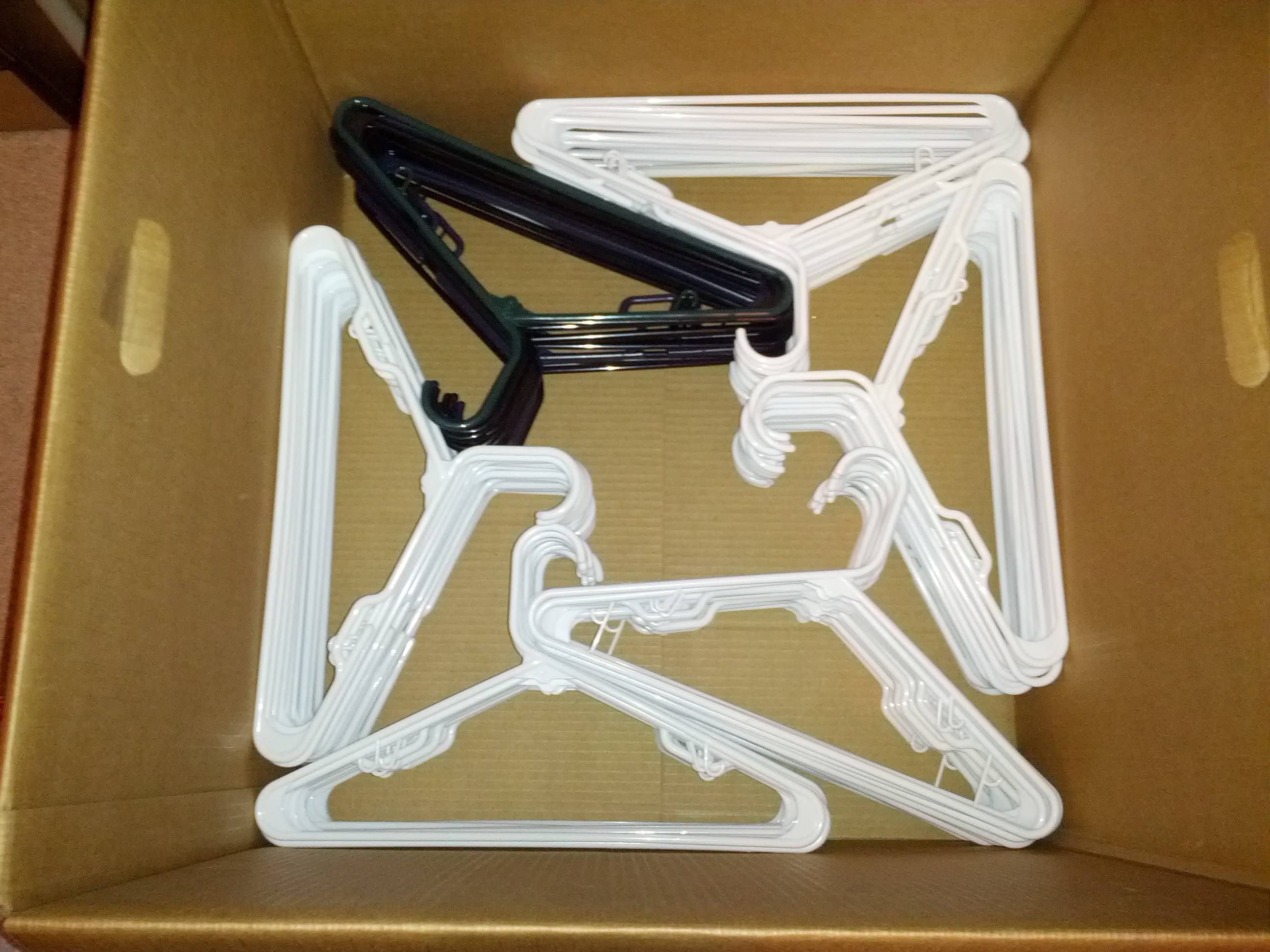 A moving box filled with neatly arranged hangers.