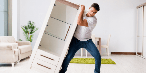 A homeowner struggling to move heavy furniture alone