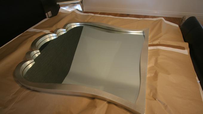 A large mirror layed out on packing paper.